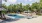 Large sparkling blue pool with a large pool deck and lounge chairs