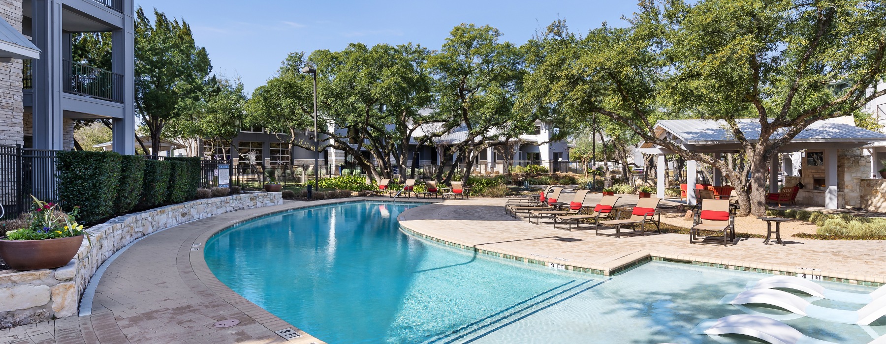 Community pool with lounge chairs and shared grills